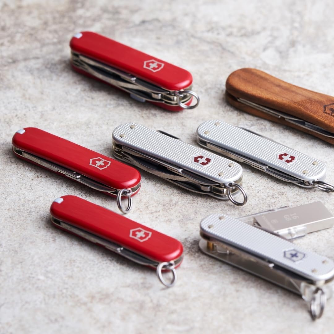 Victorinox Swiss Army Knife collection, red and silver Alox models, closed, lifestyle flat lay